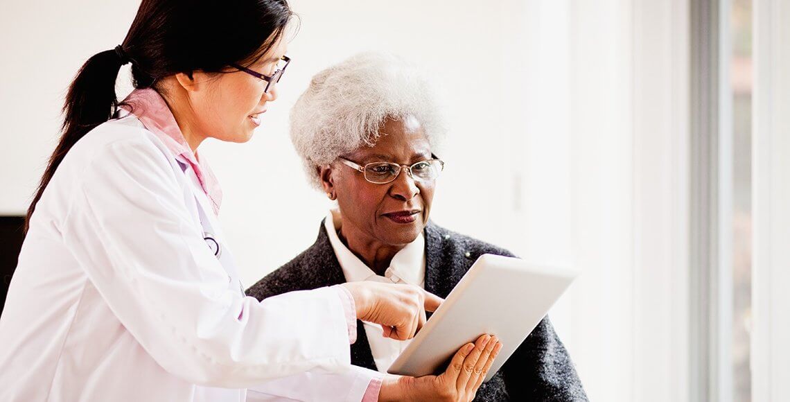 Nurse speaking to patient about her charts. 