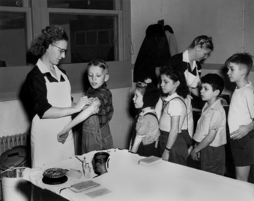Public health nurse Gladys Johnson gives immunizations to children at Linden Elementary School in Oak Ridge, Tennessee in 1946.